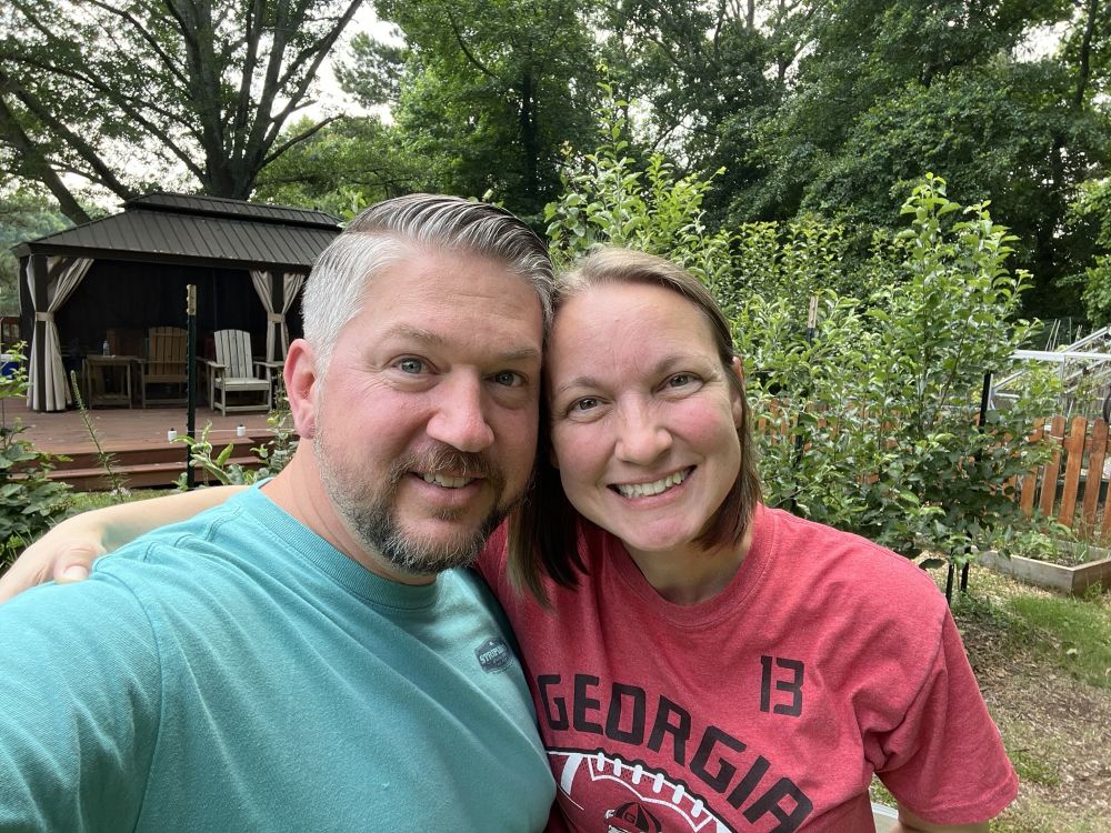 Shane and Vicki smiling together in their backyard garden